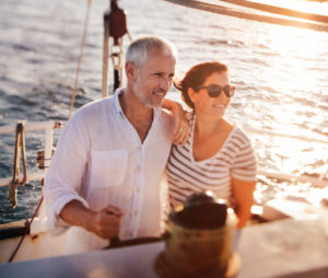 Dreamy vignate shot of senior active couple enjoying the fresh ocean breeze on their leasure cruise on their yacht
